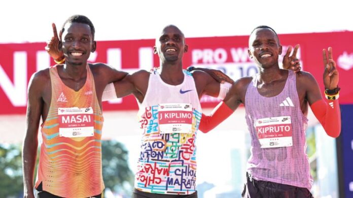 El ganador Jacob Kiplimo de Uganda, posa para una foto con el tercer clasificado Alex Masai de Kenia y el segundo clasificado Amos Kipruto de Kenia.