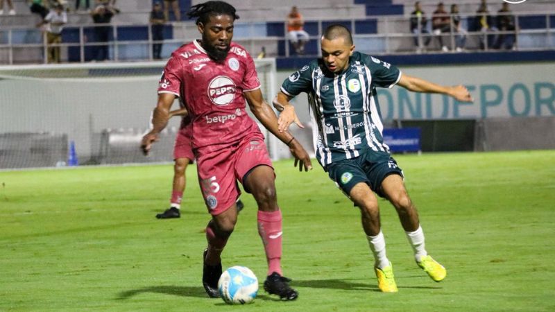 El motagüense Cristopher Meléndez cubre el balón presionado por Messy Cerrado de Juticalpa FC.
