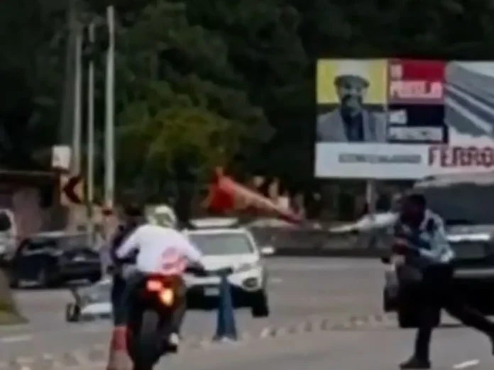 Agente de la DNVT lanza cono de tránsito a motociclista